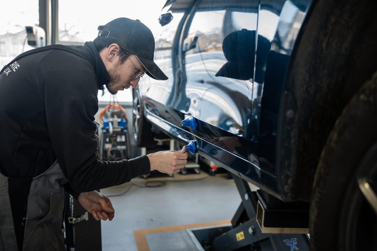 Technicien retirant une bosse sans peinture à l’aide de ventouses